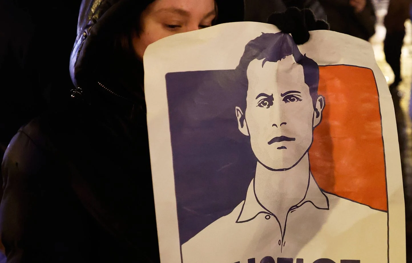 Poster de Quentin Deranque, tenu lors d’une manifestation, symbolisant la mémoire des victimes de la violence politique en France.